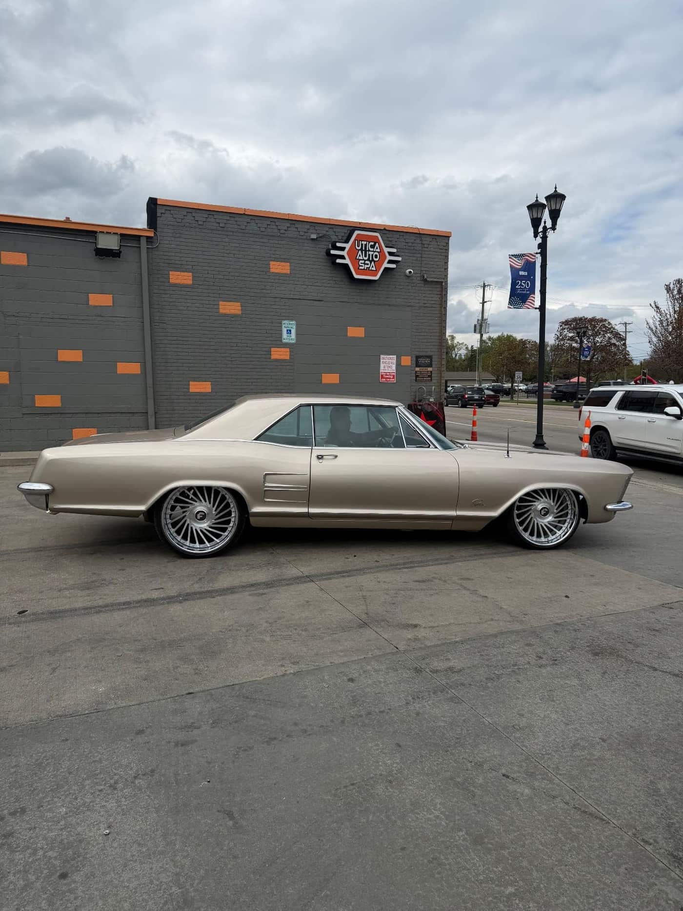 1963 Buick Riviera in champagne gold on staggered Forgiato forged wheels at Utica Auto Spa